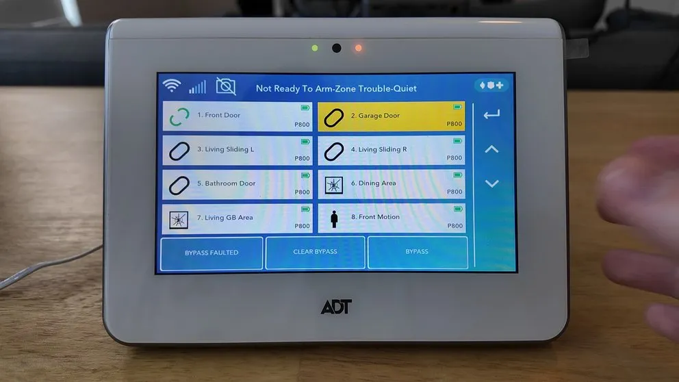 ADT panel showing the zone list with bypass options for each sensor
