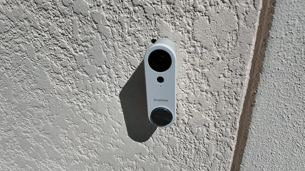 SimpliSafe doorbell camera mounted on exterior wall